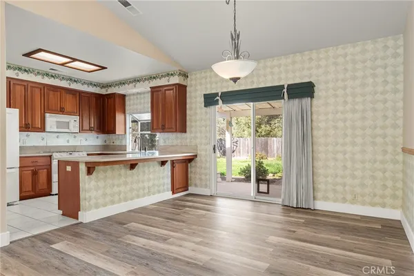 a kitchen with stainless steel appliances granite countertop a refrigerator a stove a sink and a microwave
