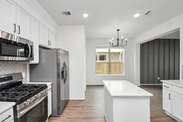 a kitchen with stainless steel appliances granite countertop a stove and a refrigerator
