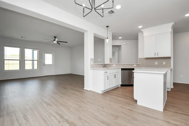 a kitchen with cabinets wooden floor and a sink