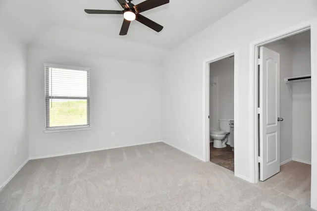 an empty room with a window and a ceiling fan