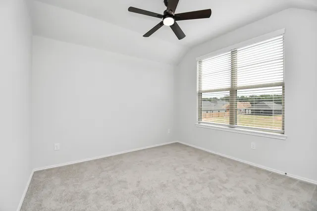 an empty room with a window and a fan
