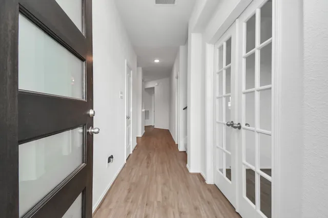 a view of a hallway with wooden floor and staircase