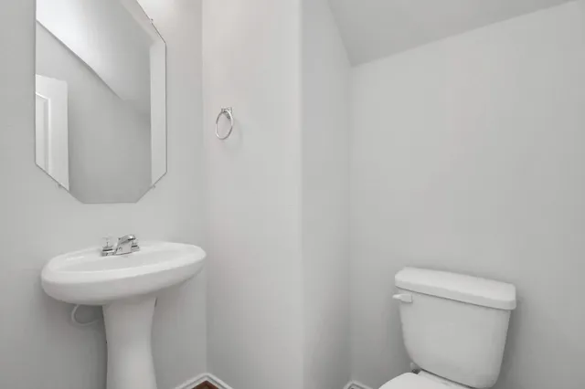 a bathroom with a sink toilet and a mirror