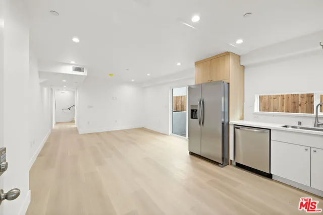 a view of a kitchen with a sink and stainless steel appliances