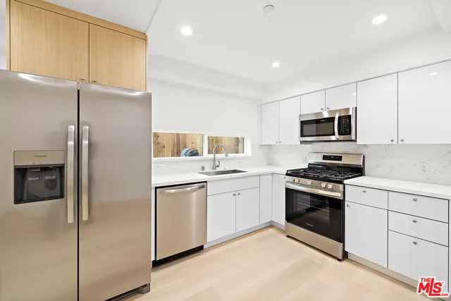a kitchen with stainless steel appliances granite countertop a refrigerator stove and sink