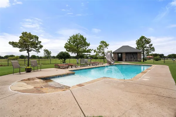 a view of swimming pool with a garden and plants