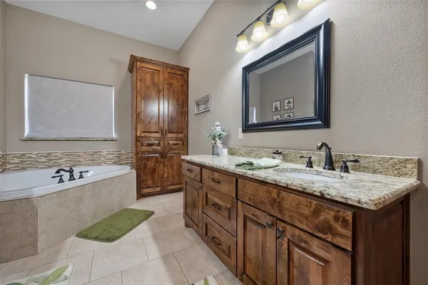 a bathroom with a tub sink and mirror