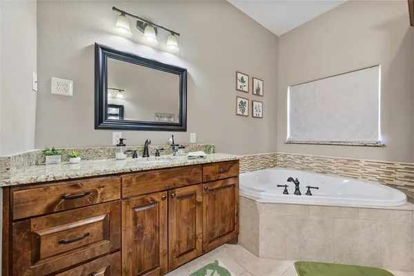 a bathroom with a granite countertop sink mirror and bathtub