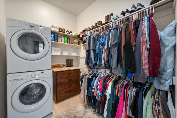 a view of walk in closet with clothes and shoes