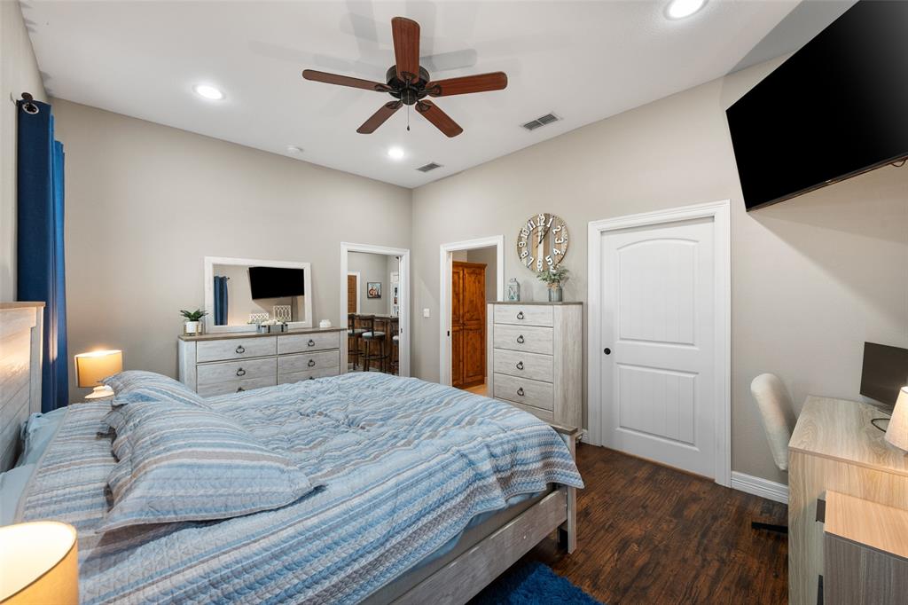 606 Sunset Point Kerens, TX 75144 - Photo 30 of 39 a bedroom with a large bed and a flat tv screen on dresser