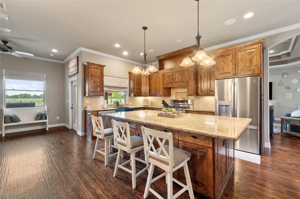 606 Sunset Point Kerens, TX 75144 - Photo 7 of 39 a kitchen with stainless steel appliances a dining table chairs and wooden floor