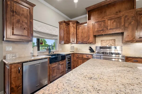 a kitchen with stainless steel appliances granite countertop a sink stove and cabinets