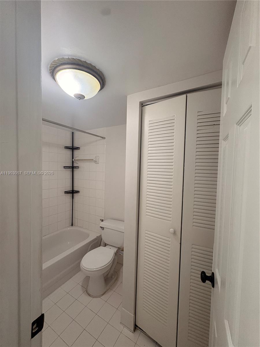 18850 Northwest 57th Avenue, Unit 306 Hialeah, FL 33015 - Photo 12 of 19 a bathroom with a granite countertop sink a toilet and shower