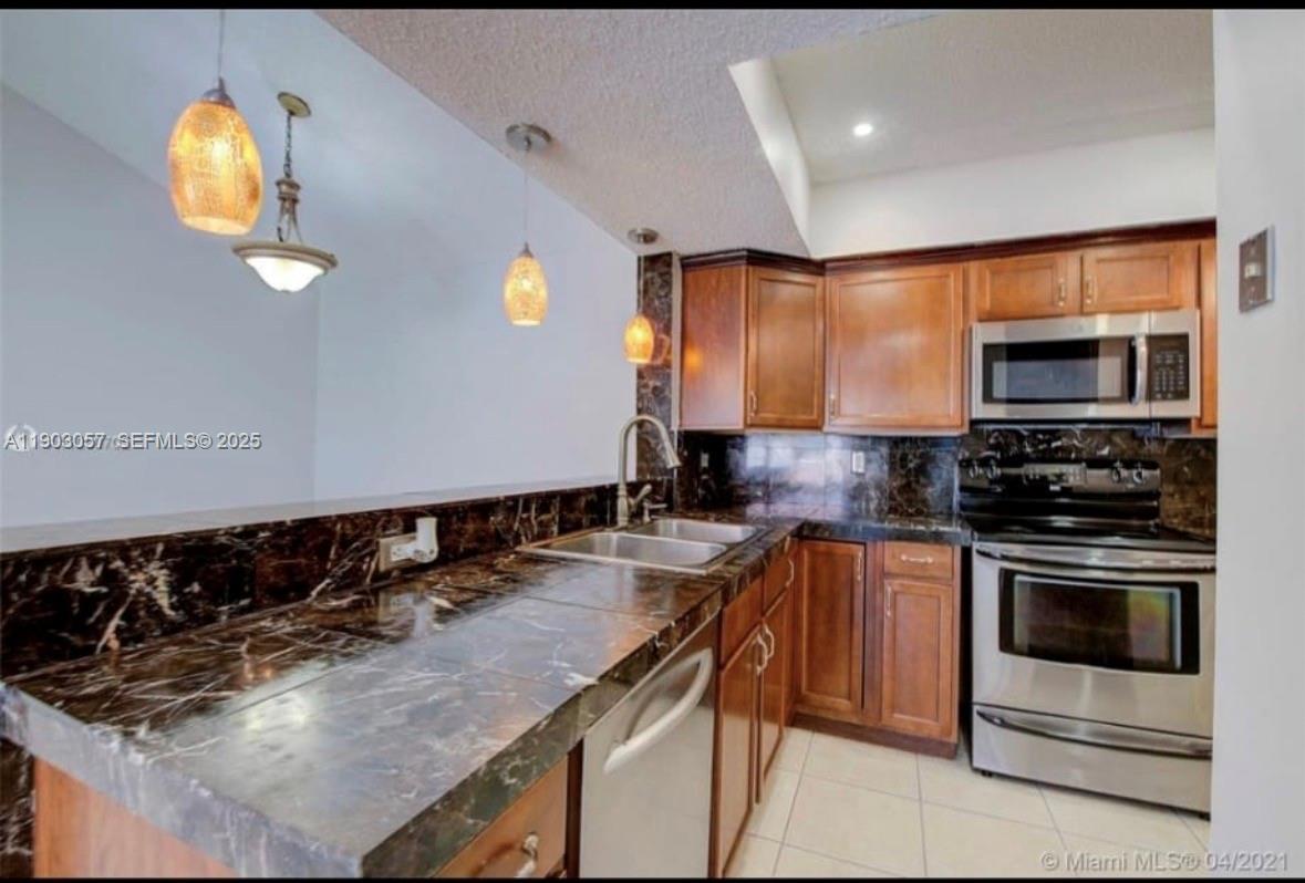 18850 Northwest 57th Avenue, Unit 306 Hialeah, FL 33015 - Photo 3 of 19 a kitchen with a sink appliances and cabinets