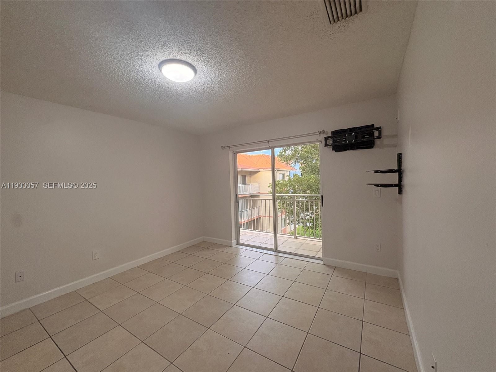 18850 Northwest 57th Avenue, Unit 306 Hialeah, FL 33015 - Photo 6 of 19 an empty room with windows and gate