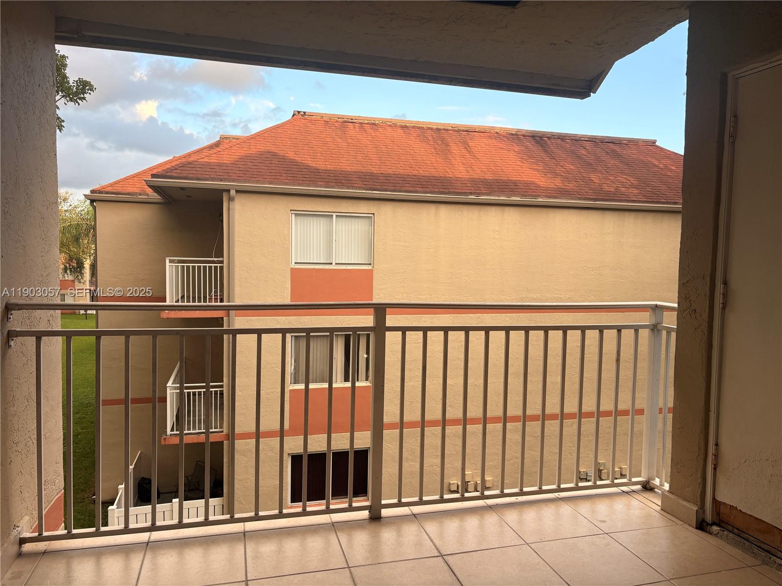 18850 Northwest 57th Avenue, Unit 306 Hialeah, FL 33015 - Photo 7 of 19 a view of a balcony with a floor to ceiling window and wooden floor