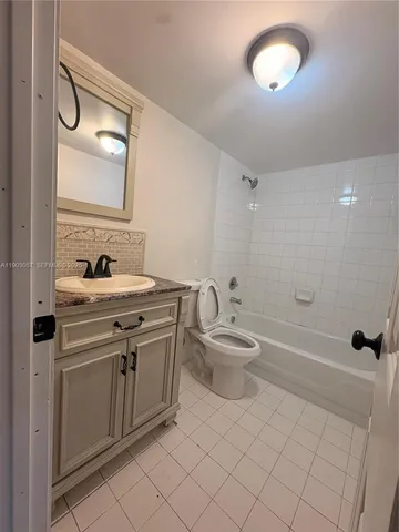 a bathroom with a granite countertop sink a toilet and shower