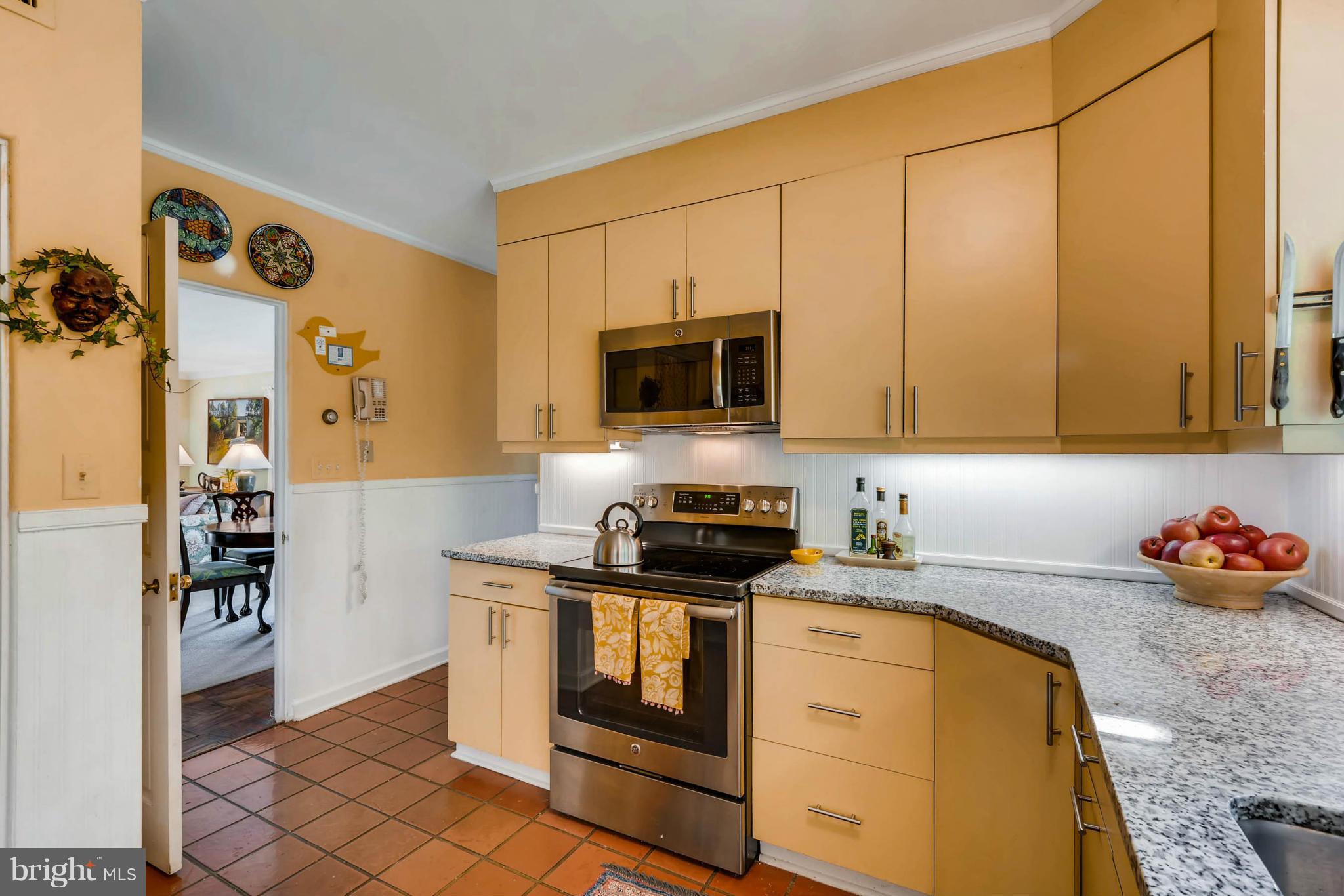 1020 St Georges Road Baltimore, MD 21210 - Photo 12 of 30 a kitchen with stainless steel appliances a stove a microwave and cabinets