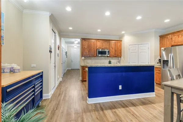 a kitchen with stainless steel appliances granite countertop a refrigerator a sink dishwasher and a stove with wooden floor