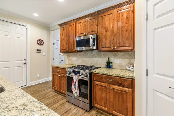 a kitchen with stainless steel appliances granite countertop a stove a sink and a microwave