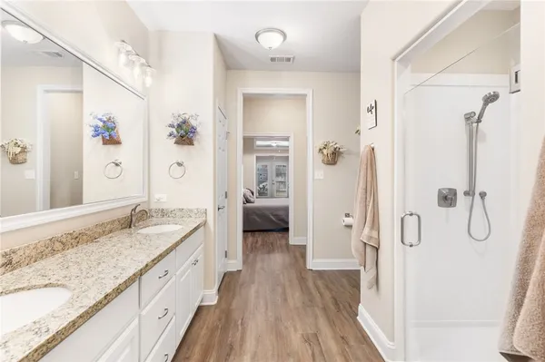 a spacious bathroom with a granite countertop vanity mirror and a shower