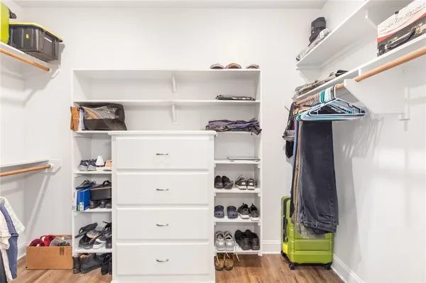 a view of walk in closet with clothes and shoes