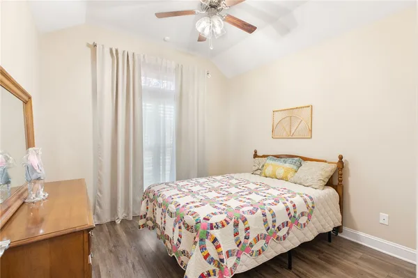 a bedroom with a bed and a dresser with wooden floor
