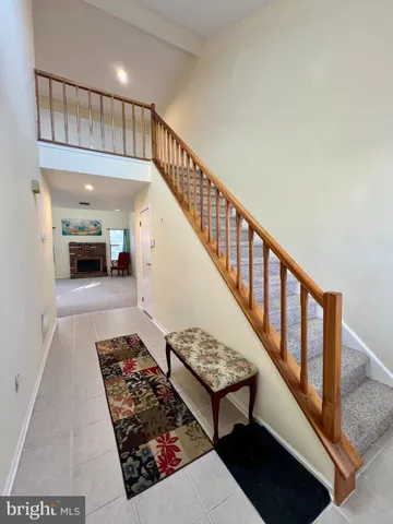 a view of staircase with lots of frames on wall and a large window
