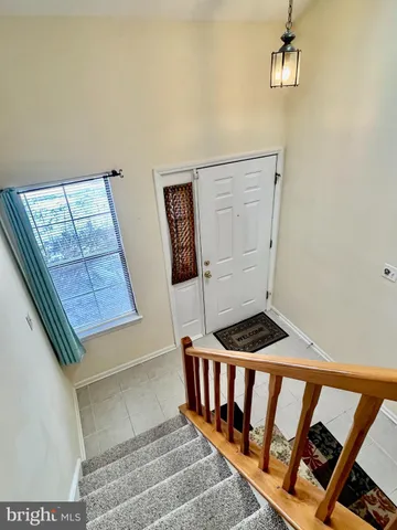 a view of staircase with white walls and a window