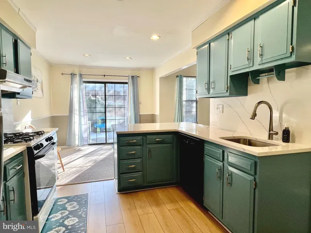 a kitchen with stainless steel appliances granite countertop a sink stove and cabinets