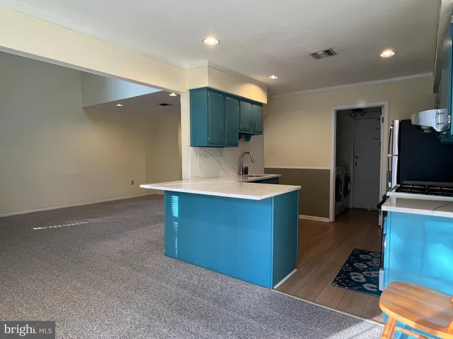 a kitchen with kitchen island a sink stainless steel appliances and cabinets