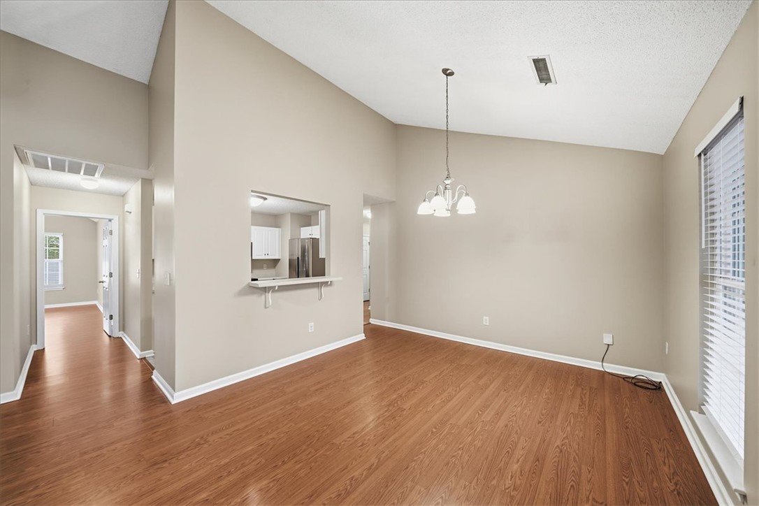 101 Grand Oak Circle Pendleton, SC 29670 - Photo 8 of 40 A graceful chandelier illuminates the vaulted ceiling and wood flooring in this spacious dining area.