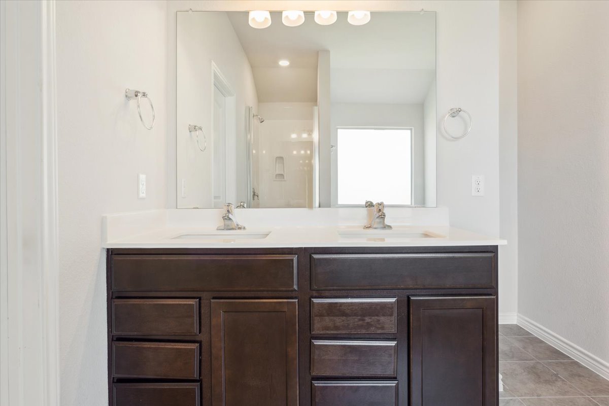 5830 Copano Road Belton, TX 76513 - Photo 21 of 34 Bathroom with a stall shower, a sink, baseboards, and tile patterned floors