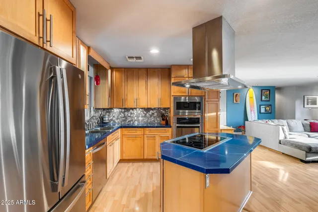 a kitchen with stainless steel appliances kitchen island granite countertop a table and chairs