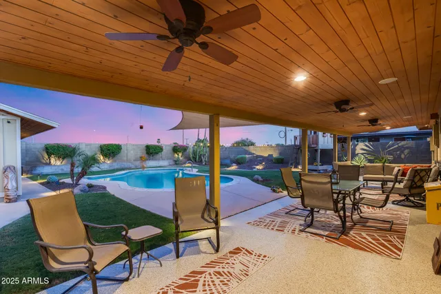 a view of a patio with table and chairs and a barbeque