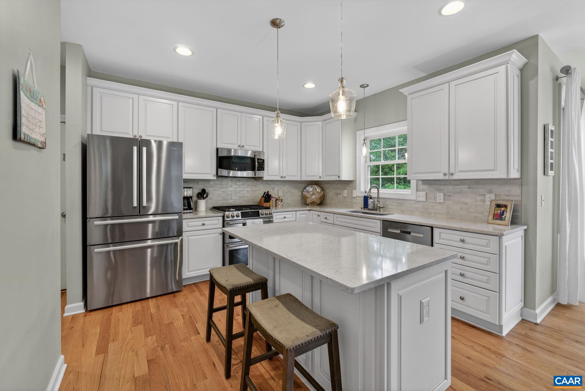 511 Taylor Ridge Way Palmyra, VA 22963 - Photo 16 of 57 a kitchen with kitchen island a refrigerator stove microwave and cabinets