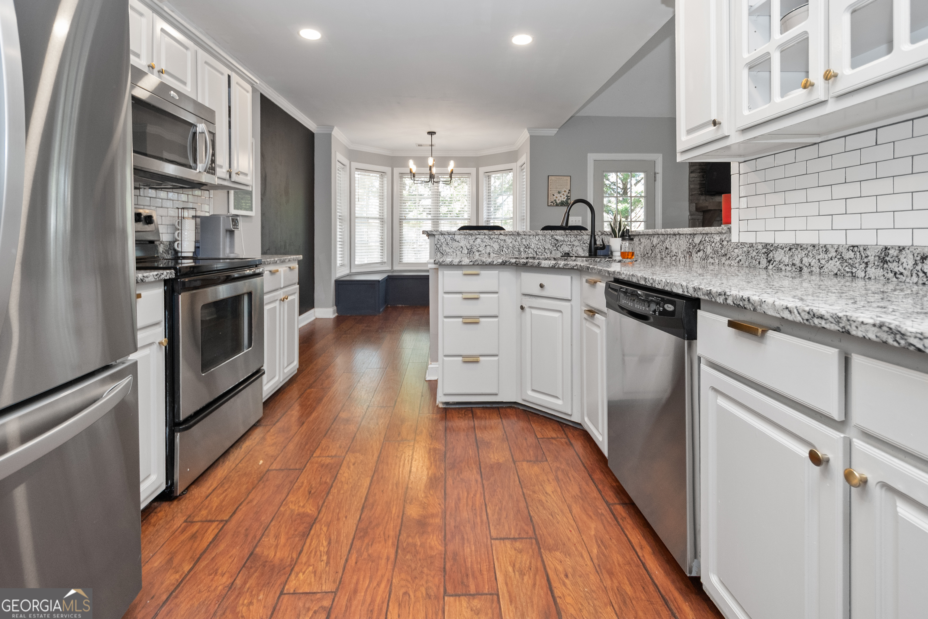 568 Martin Mill Road Moreland, GA 30259 - Photo 16 of 70 a kitchen with stainless steel appliances granite countertop hardwood floor sink stove and wooden cabinets