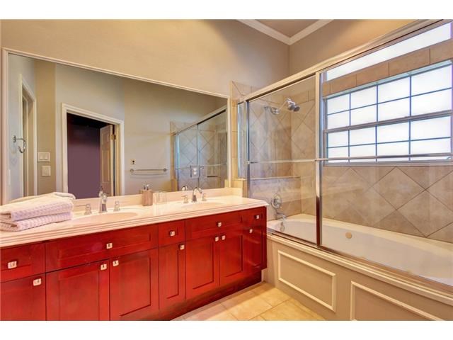 2918 Ranch Road 620, Unit K170 Austin, TX 78734 - Photo 8 of 22 Double vanity sinks and an inviting tub with a glass-enclosed shower await in this well-appointed bathroom.