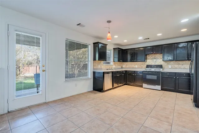 a large white kitchen with a large window