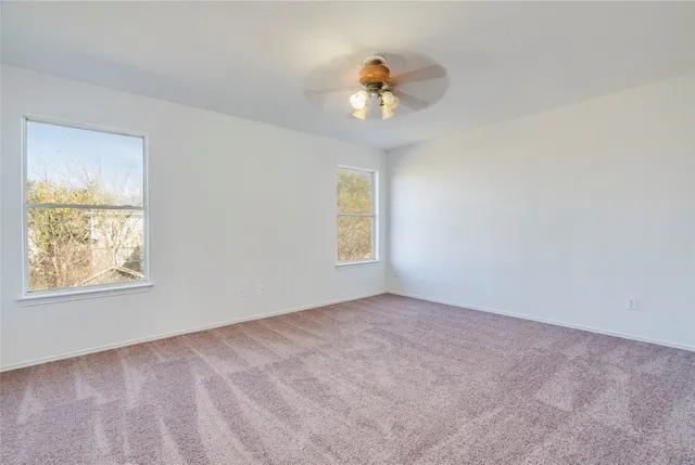 a view of an empty room with a chandelier fan
