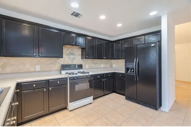 a kitchen with stainless steel appliances granite countertop a refrigerator and a stove top oven