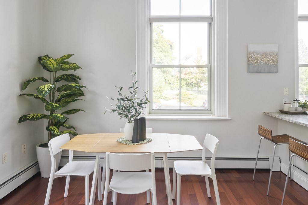 145 Glenwood Street, Unit 204 Malden, MA 02148 - Photo 3 of 13 a dining room with furniture potted plants and wooden floor