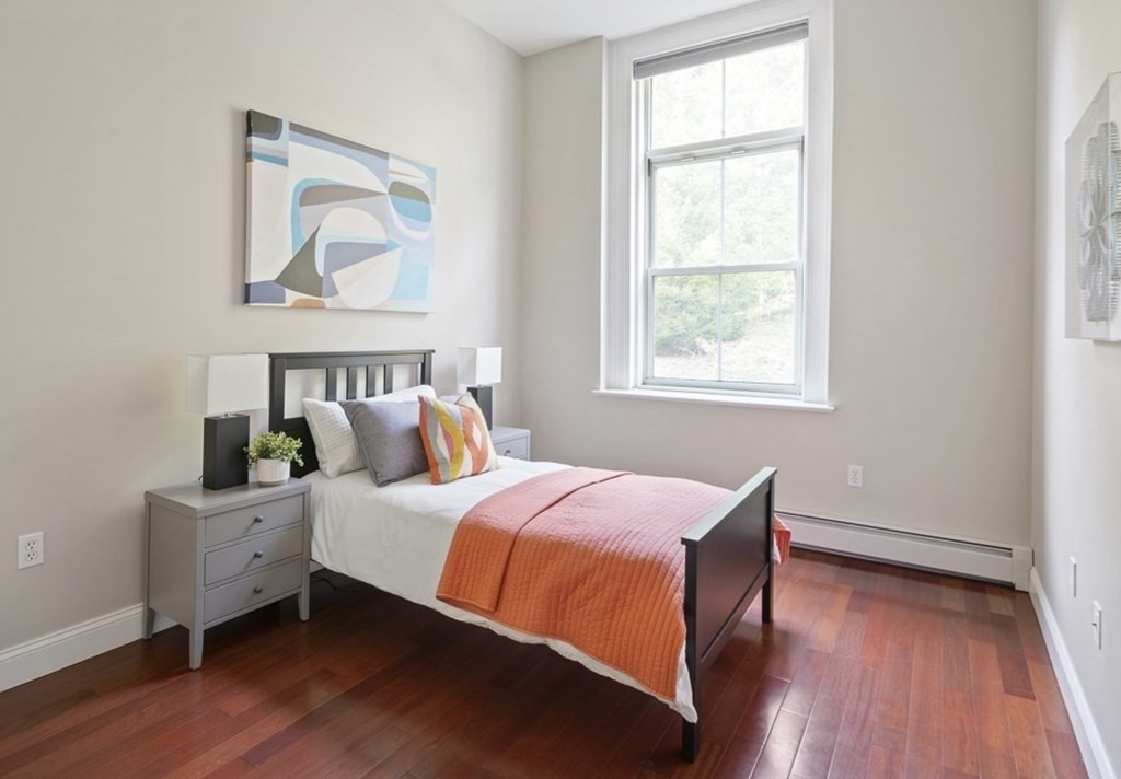 145 Glenwood Street, Unit 204 Malden, MA 02148 - Photo 9 of 13 a bedroom with a bed and wooden floor