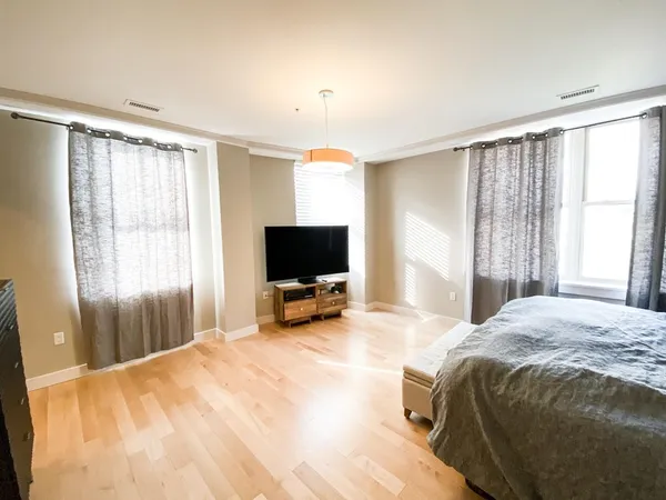 a bedroom with a bed and a flat screen tv on dresser