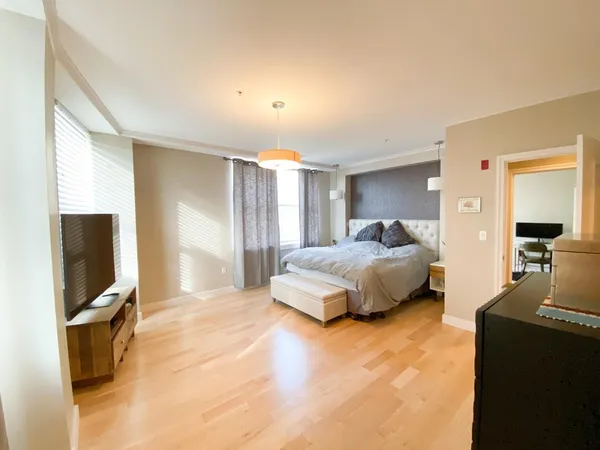 a spacious bedroom with a bed and a flat screen tv
