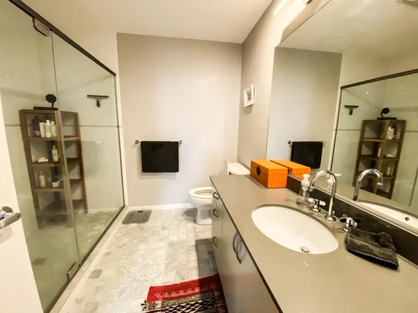 a bathroom with a granite countertop sink a mirror and shower