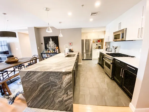 a large kitchen with stainless steel appliances kitchen island granite countertop a large counter top and stove top oven