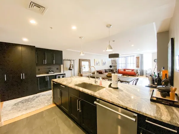 a kitchen with stainless steel appliances granite countertop a sink a stove and a refrigerator