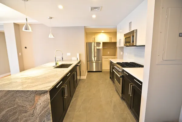 a kitchen with stainless steel appliances granite countertop a sink stove and refrigerator
