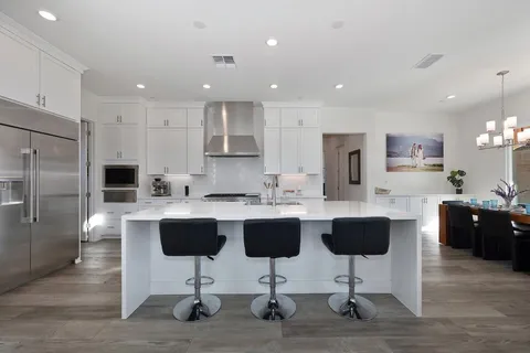a kitchen with white cabinets and appliances